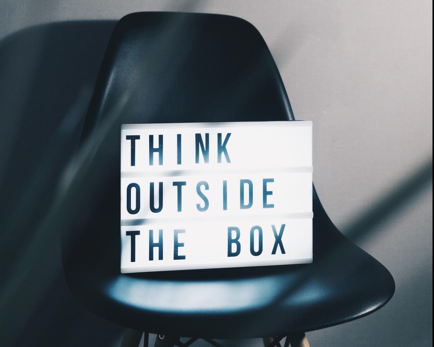 A sign displaying the words THINK OUTSIDE THE BOX